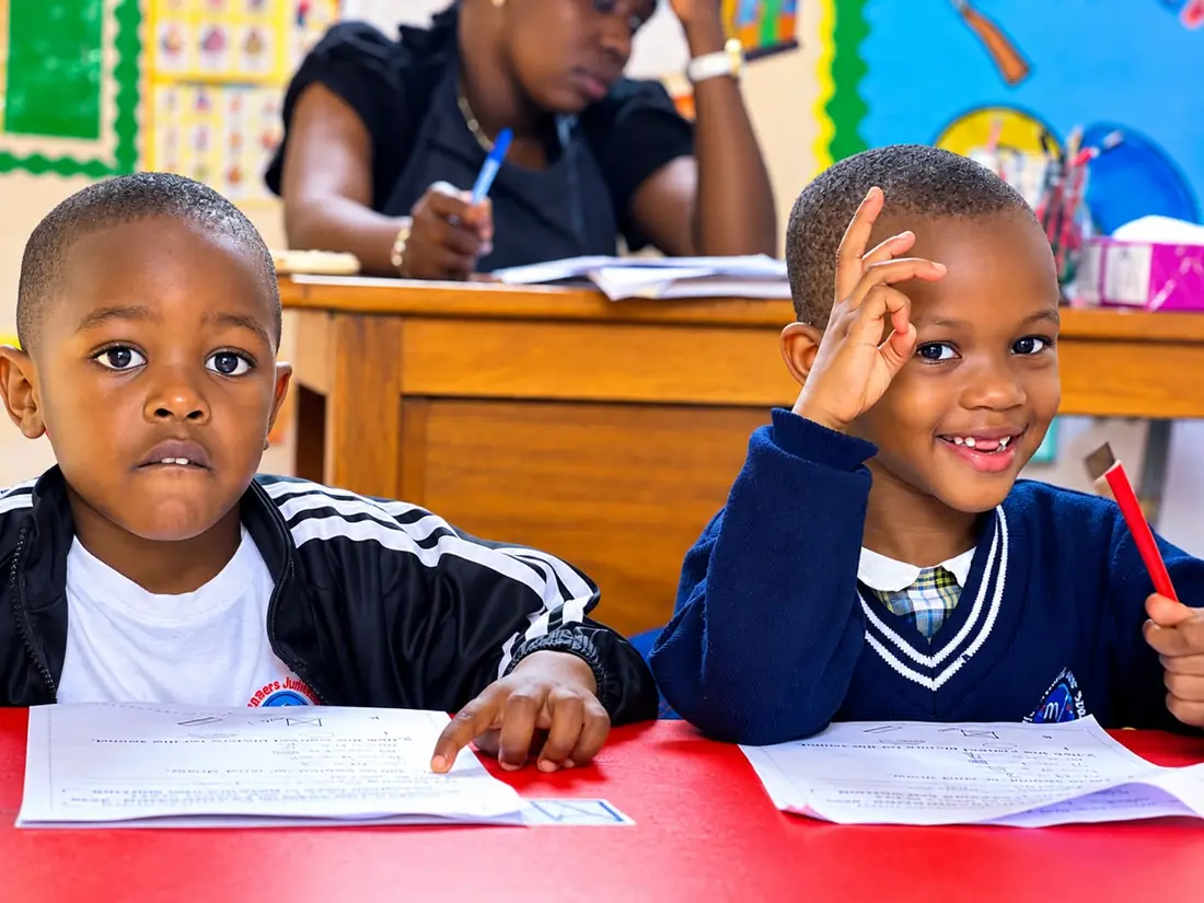 A teacher leads a lesson while pupils work at their desks